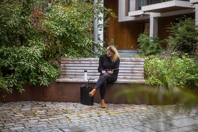 Kvinne som avslappet skriver i dagboken under en utendørs fotoshoot i Oslo, Norge, med naturlig og profesjonell visuell innholdsproduksjon