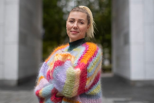 Naturlig portrett av en kvinne i en komfortabel, varm outfit, fanget under en utendørs merkevarefotografering i Oslo med profesjonell visuell innholdsproduksjon