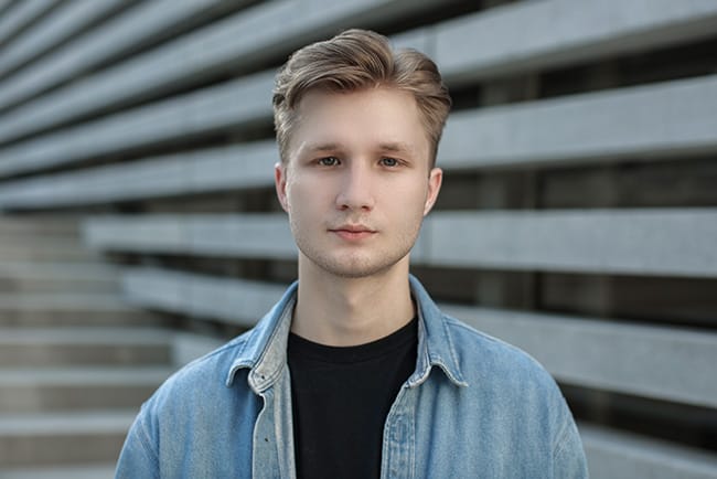Portrett av en ung mann med et rolig og naturlig uttrykk, som utstråler en profesjonell og autentisk merkevarefølelse