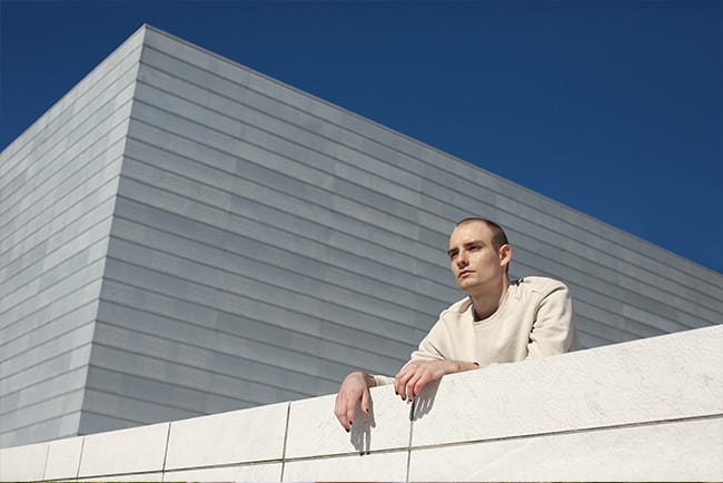Mann ute, naturlig utseende, ser tankefull ut, personlig merkevarebilde av en profesjonell fotograf utenfor Operaen i Oslo, urban komposisjon, leken stemning